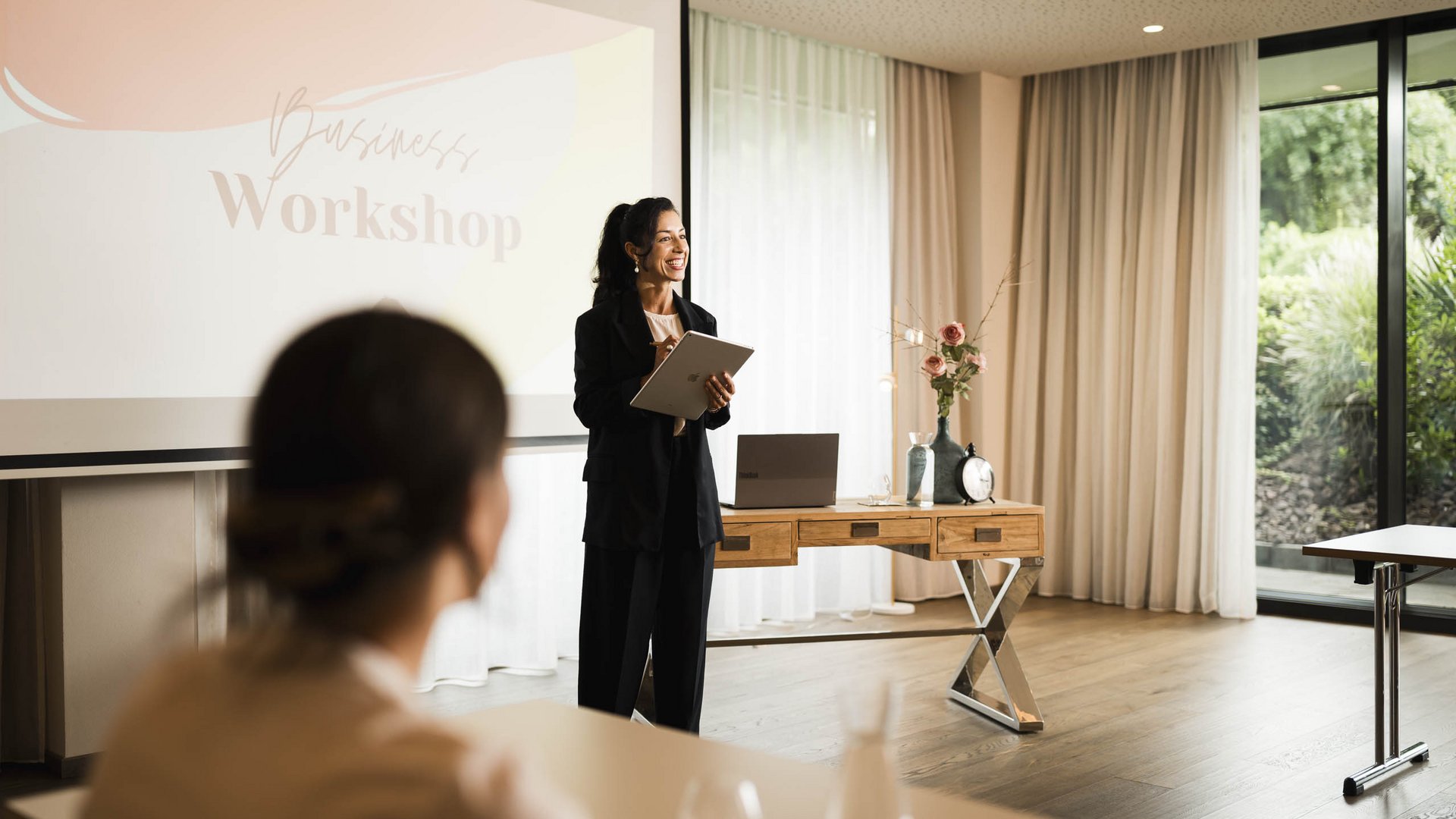 Schenna Resort Eine Frau leitet einen Workshop vor einer Leinwand, während eine Teilnehmerin zuhört