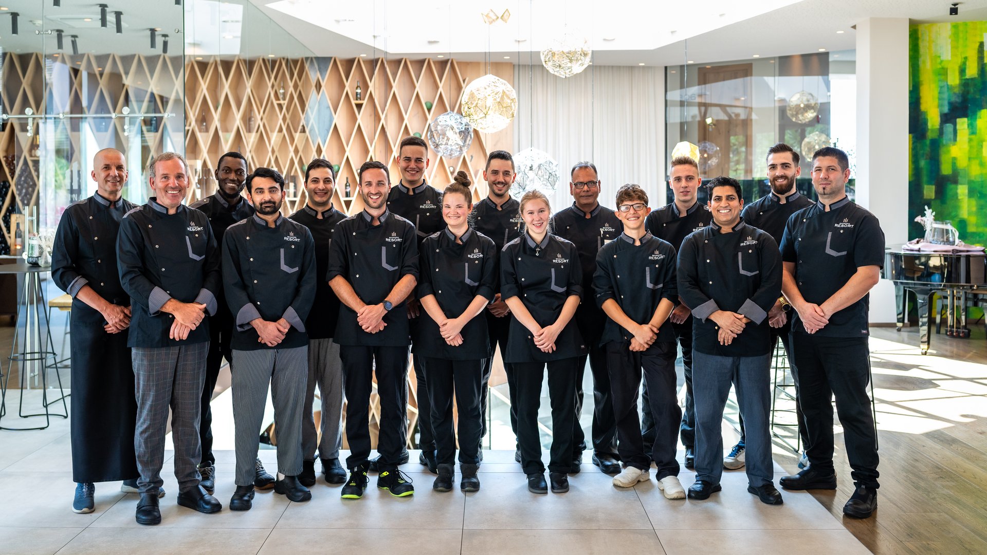 Schenna Resort Gruppe von Küchenmitarbeitern in schwarzer Uniform in einem modernen Restaurant