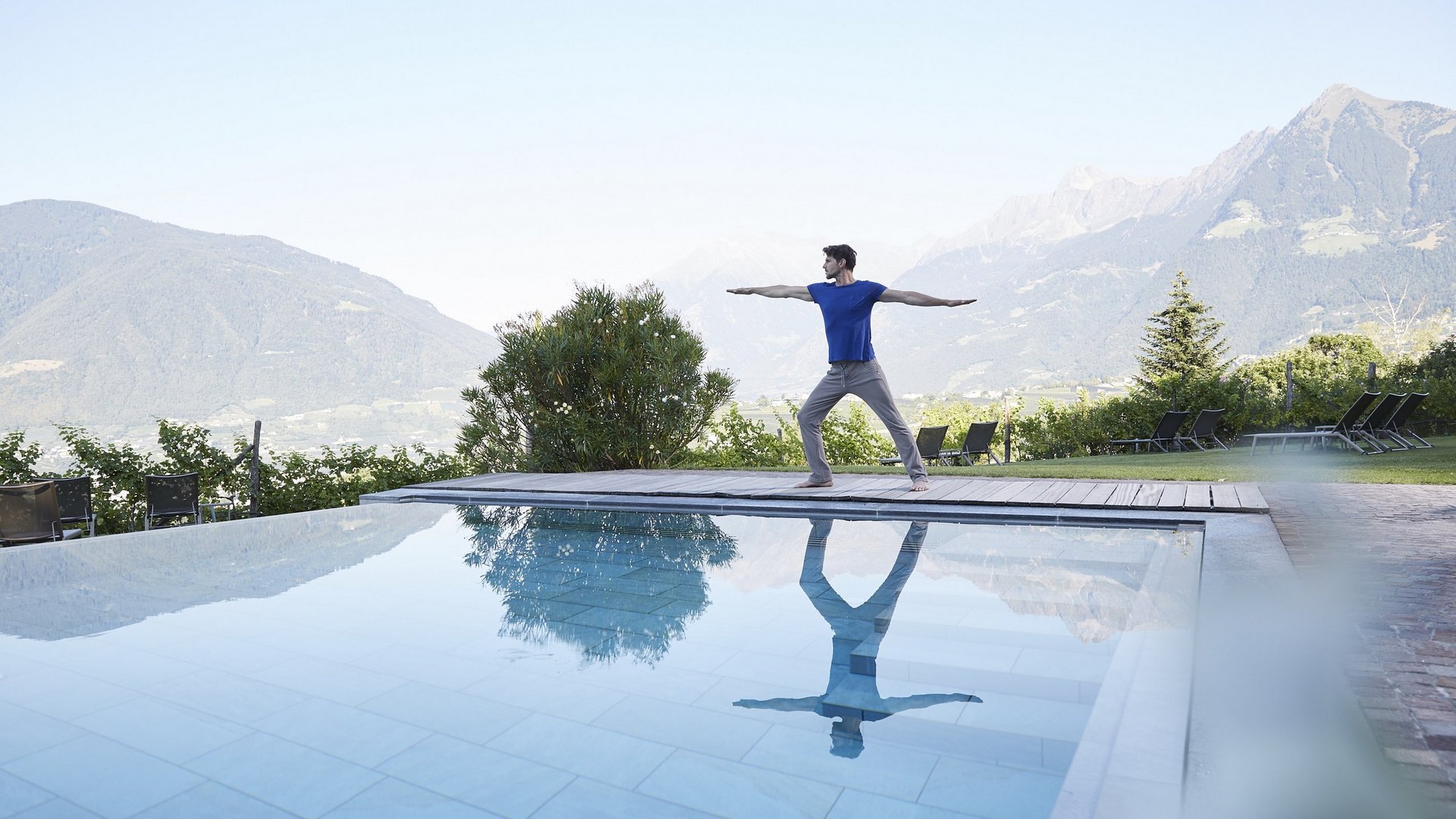 Yoga & Mindfulness am Pool mit Blick auf die Meraner Bergwelt beim Wellnessurlaub im Spa Hotel Schenna Resort bei Meran