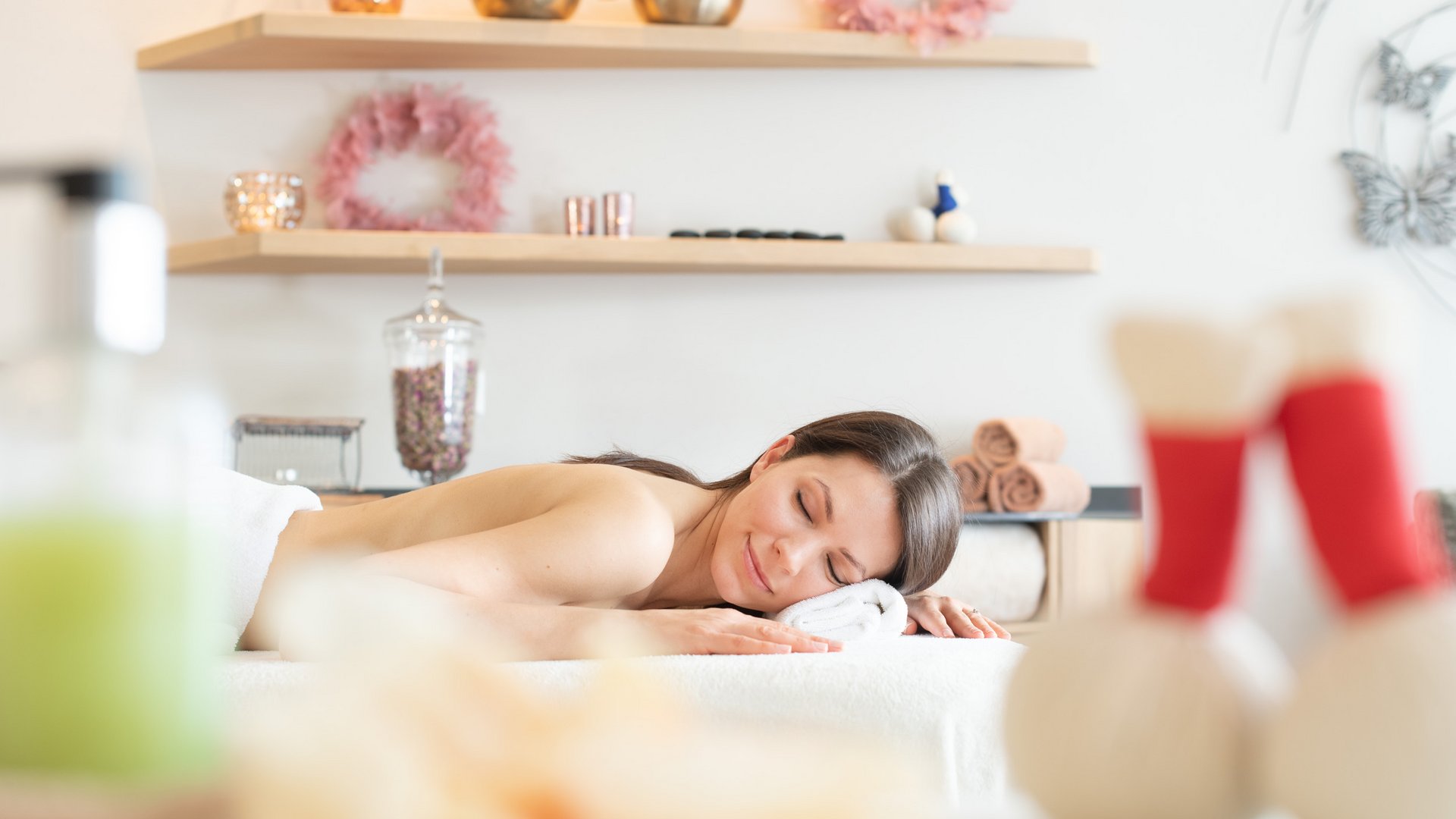 Woman relaxing on massage table in bright spa room